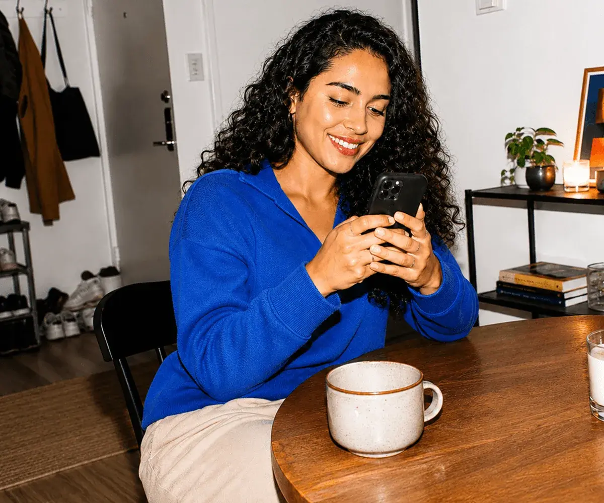 Person browsing jobs on the EarnIn app over coffee